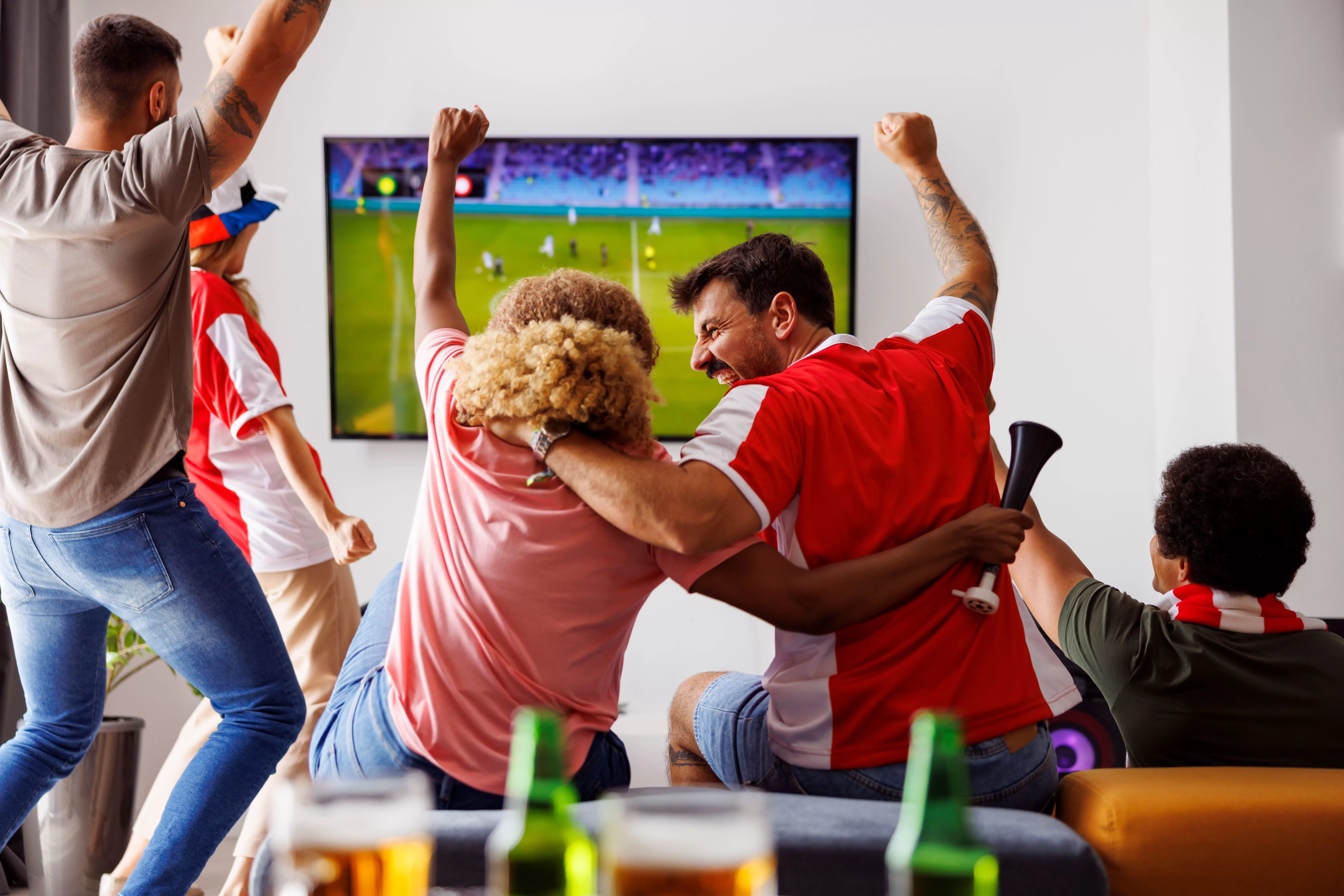 Família comemorando enquanto assiste futebol